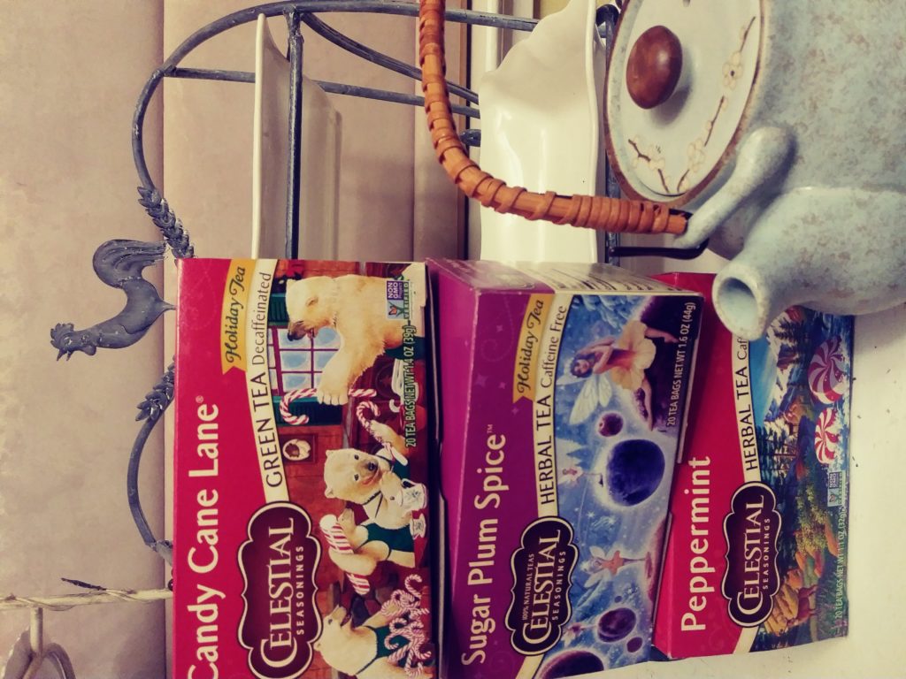 Celestial Seasonings sugar plum spice, candy cane lane and pepperrmint boxed teas next to a tea pot