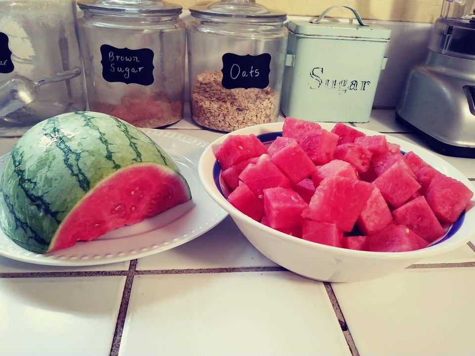 watermelon cubes in bowl and half a watermelon