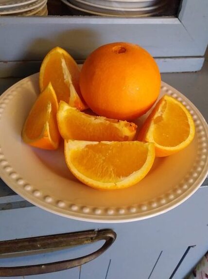 oranges whole and slices on a plate