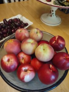 Nectarines and peaches in a bowl, cherries on a tray