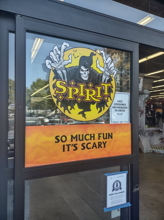 Spirit Halloween door sign that says, "So much fun it's scary"  with the grim reaper