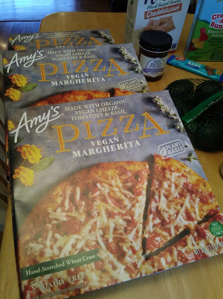 Three boxes of Amy's vegan Margherita pizza on my dining table