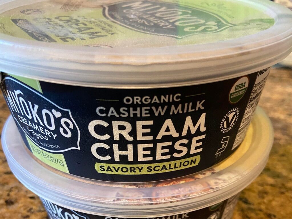 two tubs of Miyoko's cream cheeses, savory scallion and everything flavors