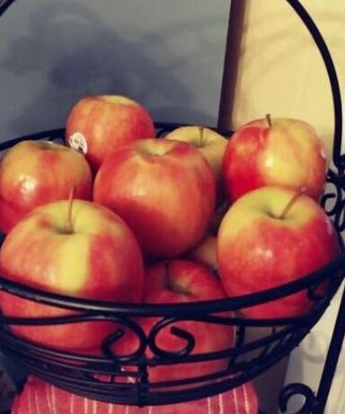 Pink Lady Apples in a black wire basket
