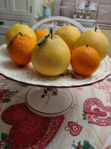 oranges and grapefruits on a decorative cake stand pedestal