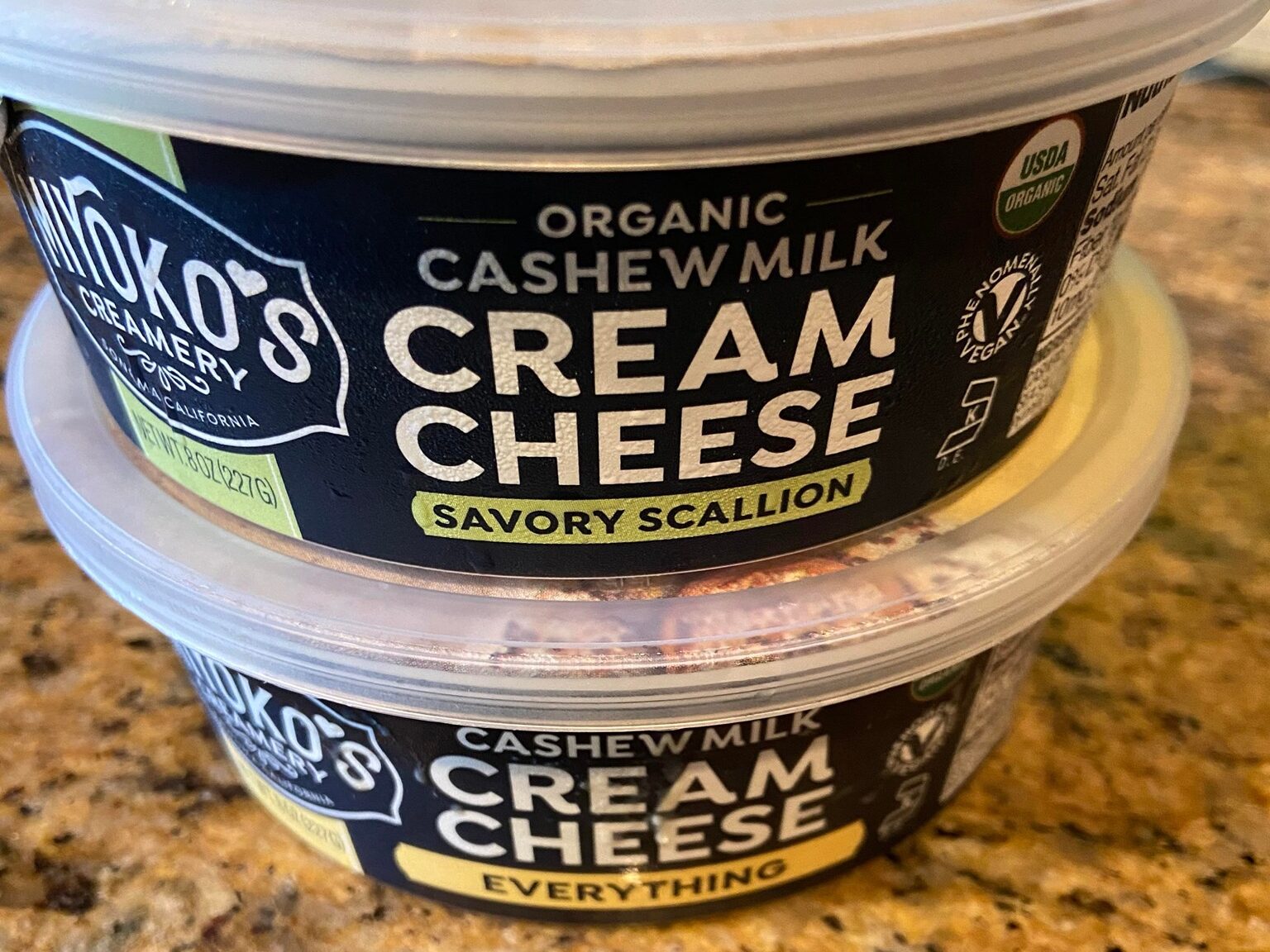 two tubs of Miyoko's cream cheeses, savory scallion and everything flavors