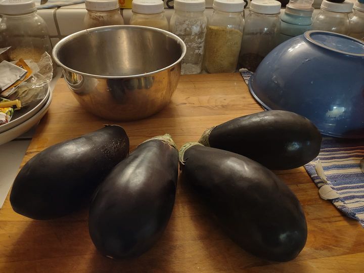 four eggplants on cutting board