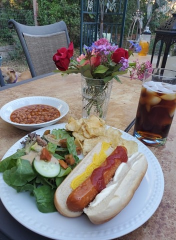 4th of July table with vegan hot dog, flowers and beans