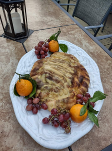 tofu turkey on white platter with red grapes and oranges