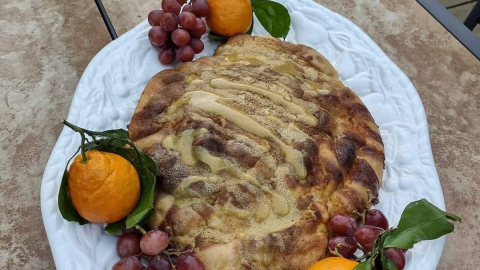tofu turkey on white platter with red grapes and oranges