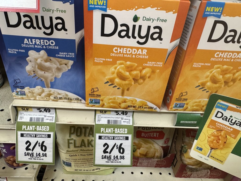 Daiya Deluxe mac and cheese boxes on store shelf - cheddar and alfredo flavors