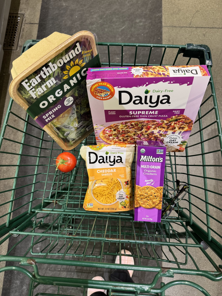 Whole Foods cart with Daiya supreme pizza, Daiya cheddar shreds, tomato, Milton's crackers, Earthbound Farm organic spring mix